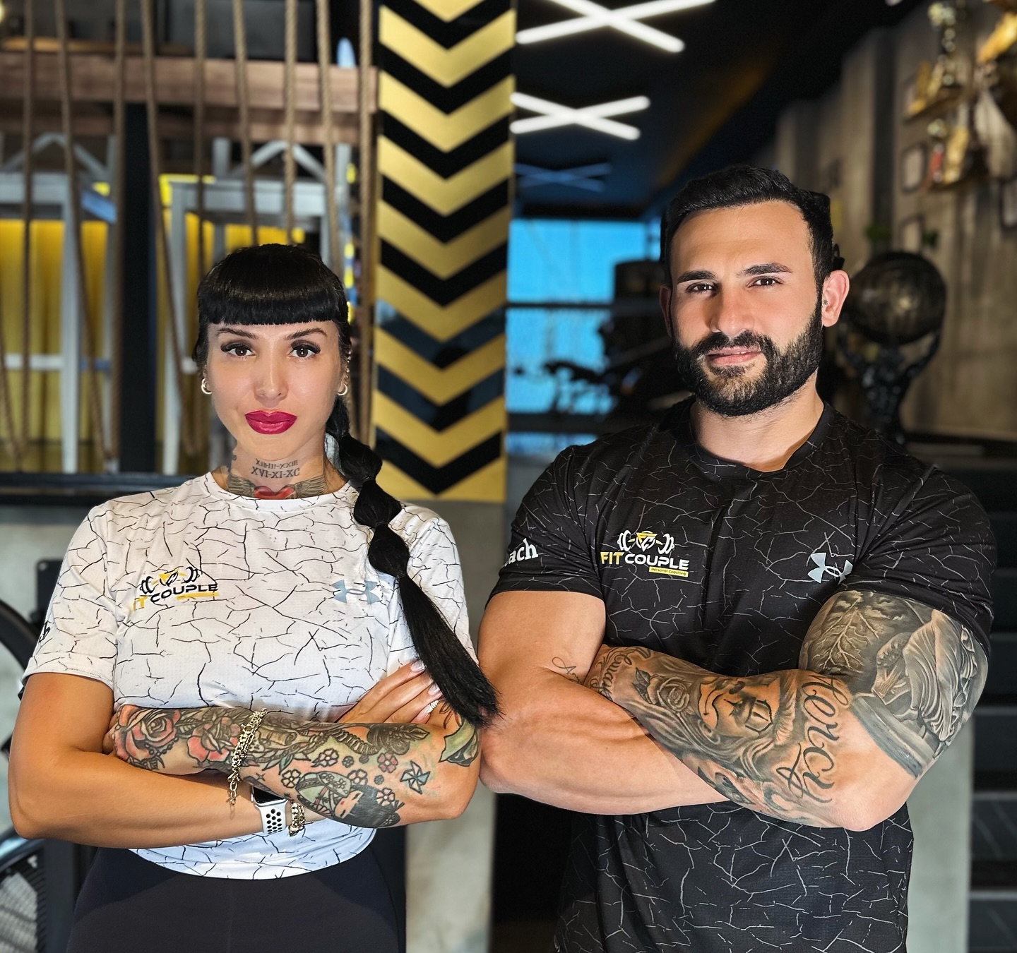 Fit Couple ekibinden iki eğitmen stüdyoda birlikte poz veriyor